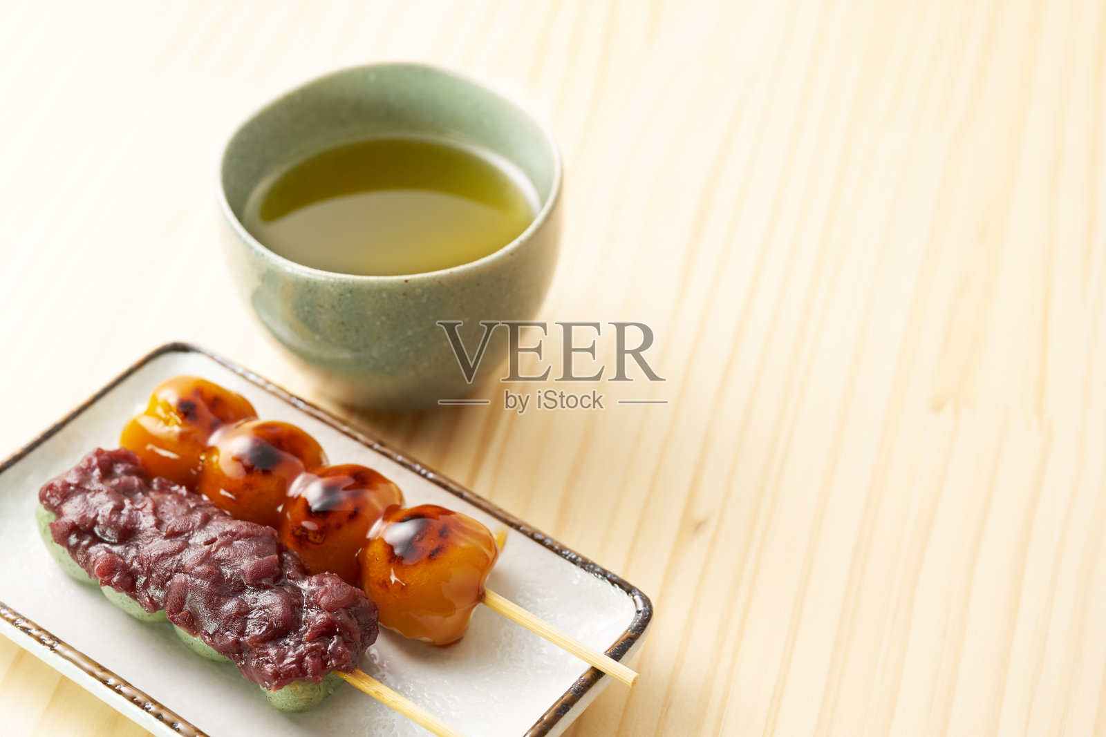 木桌上的三足串和草麻串照片摄影图片