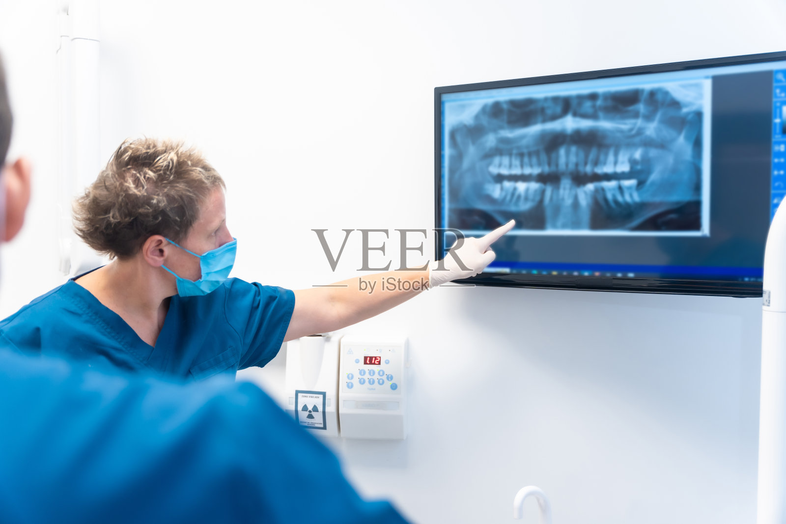 牙科诊所，坐着的病人和牙医谈论他们将要进行的治疗照片摄影图片