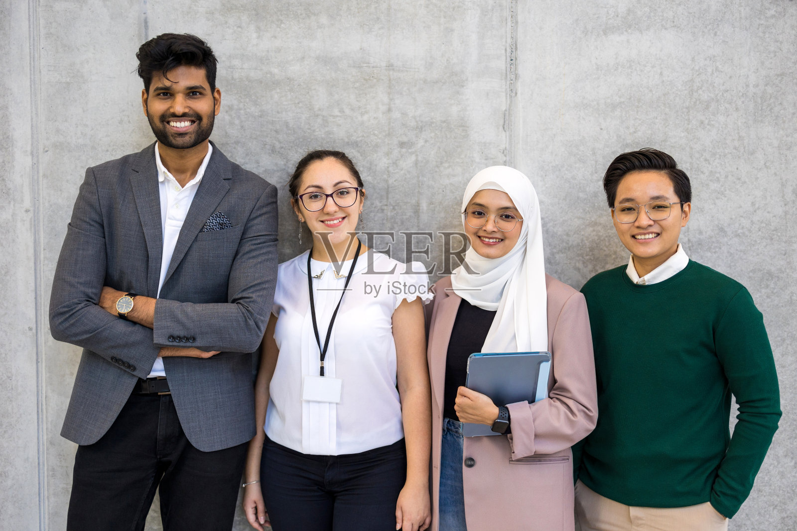 一群形形色色的商人站在一堵灰色的墙上照片摄影图片