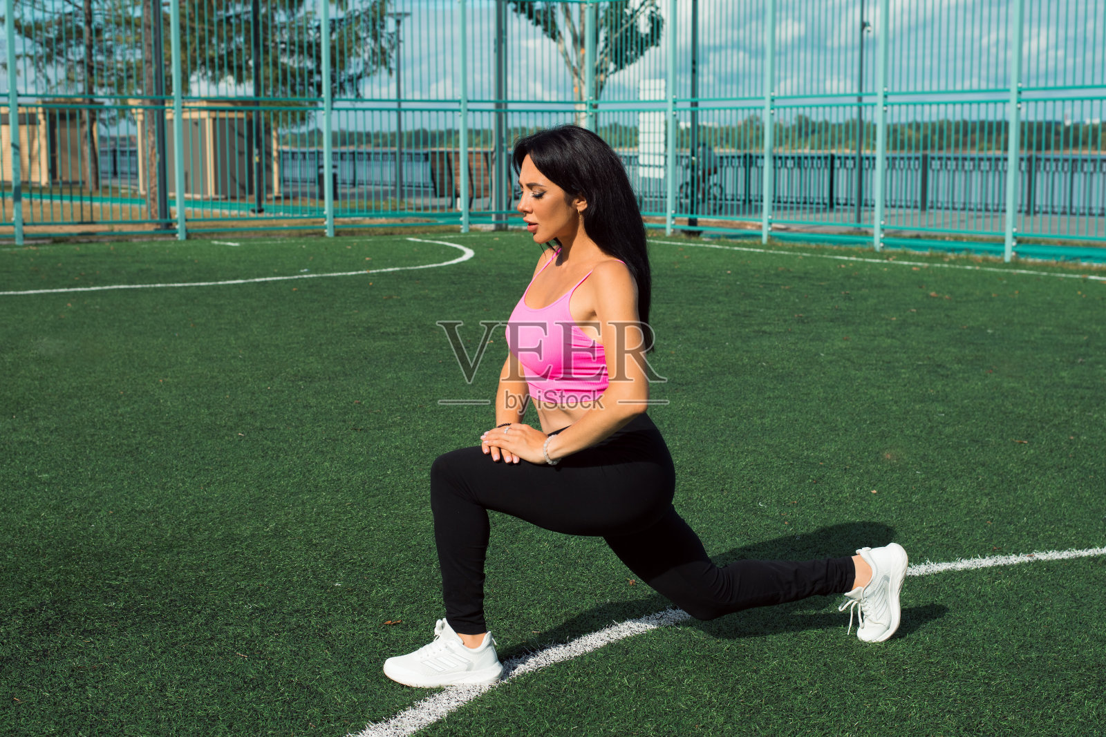 深色头发的女人在户外运动场上锻炼照片摄影图片