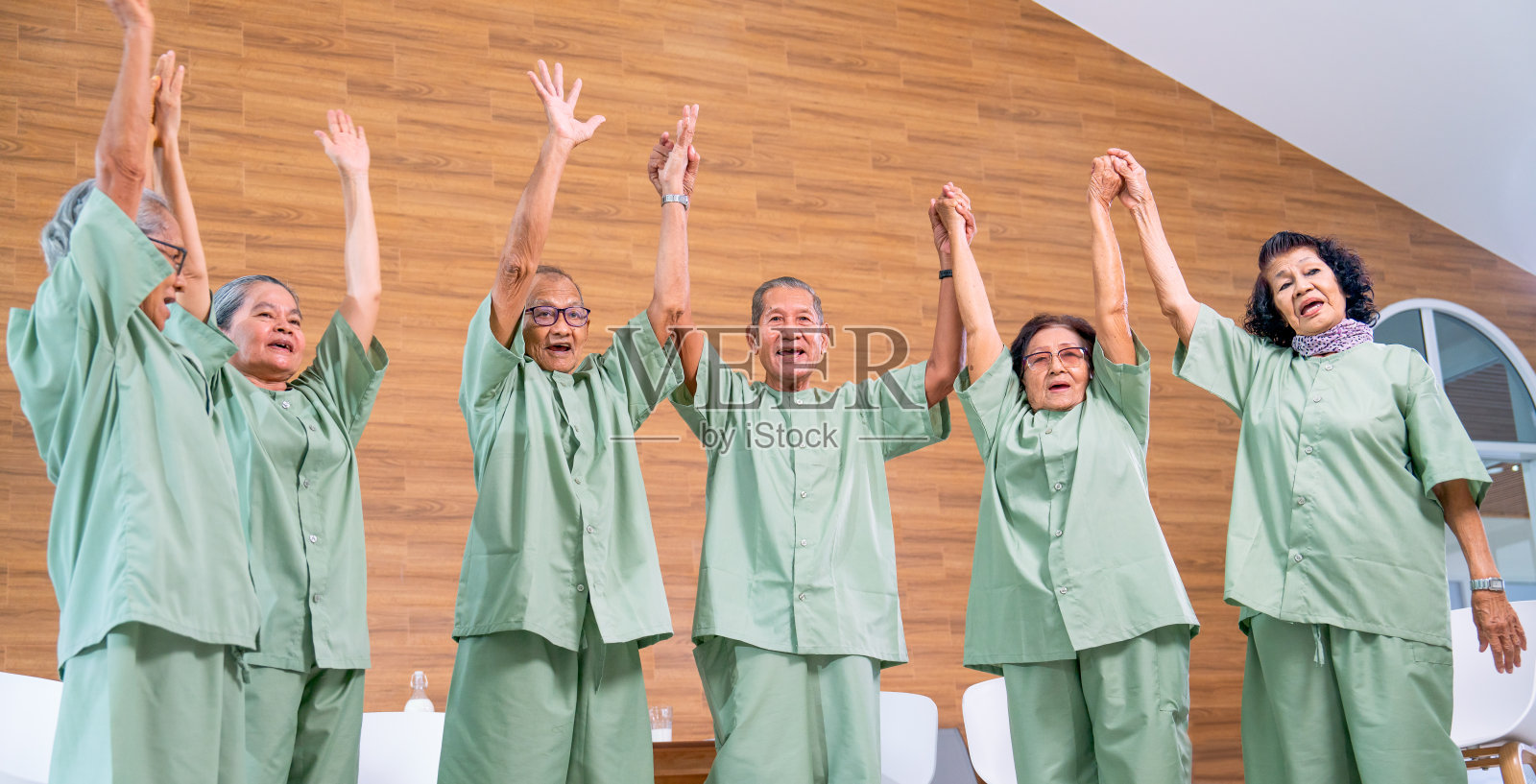 亚洲的老年男女举起双手，表达对老年社会健康、快乐的幸福。照片摄影图片