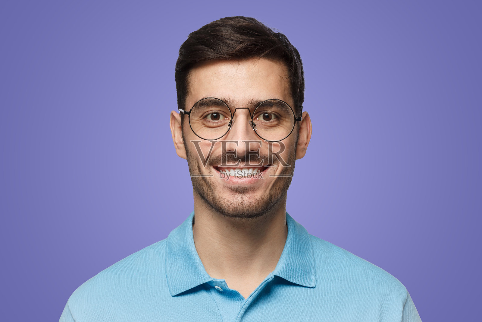 近距离的肖像年轻微笑的帅哥在蓝色polo衫和圆眼镜照片摄影图片