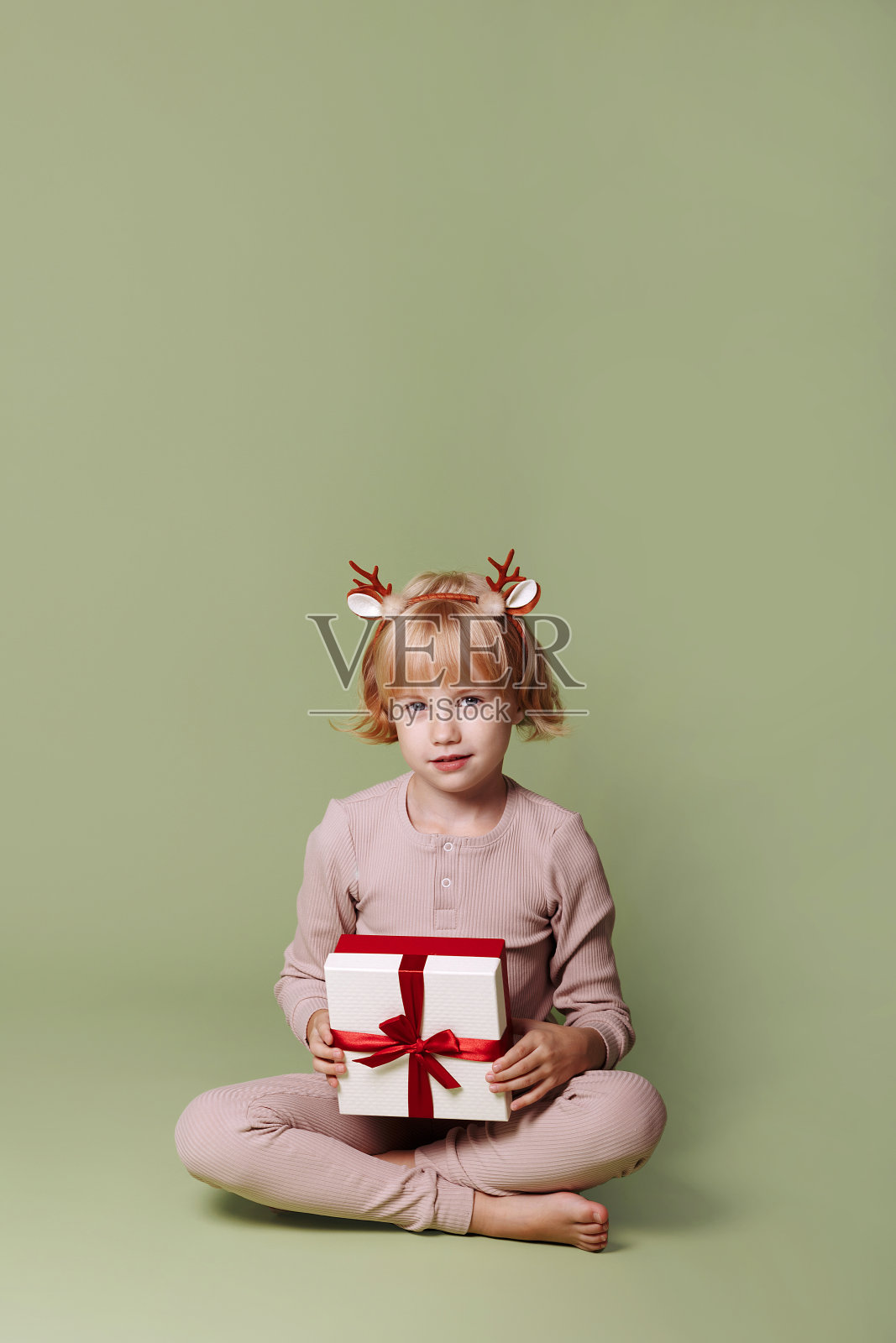 绿色背景的圣诞礼物女孩。照片摄影图片