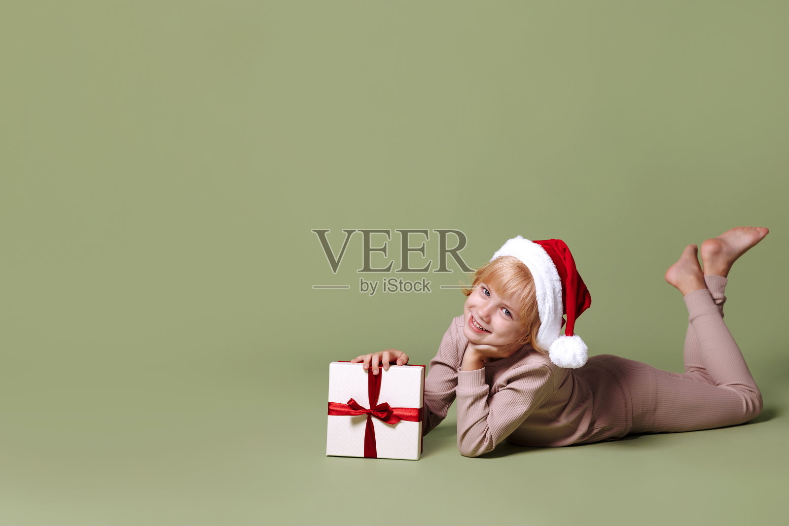 绿色背景的圣诞礼物女孩。照片摄影图片