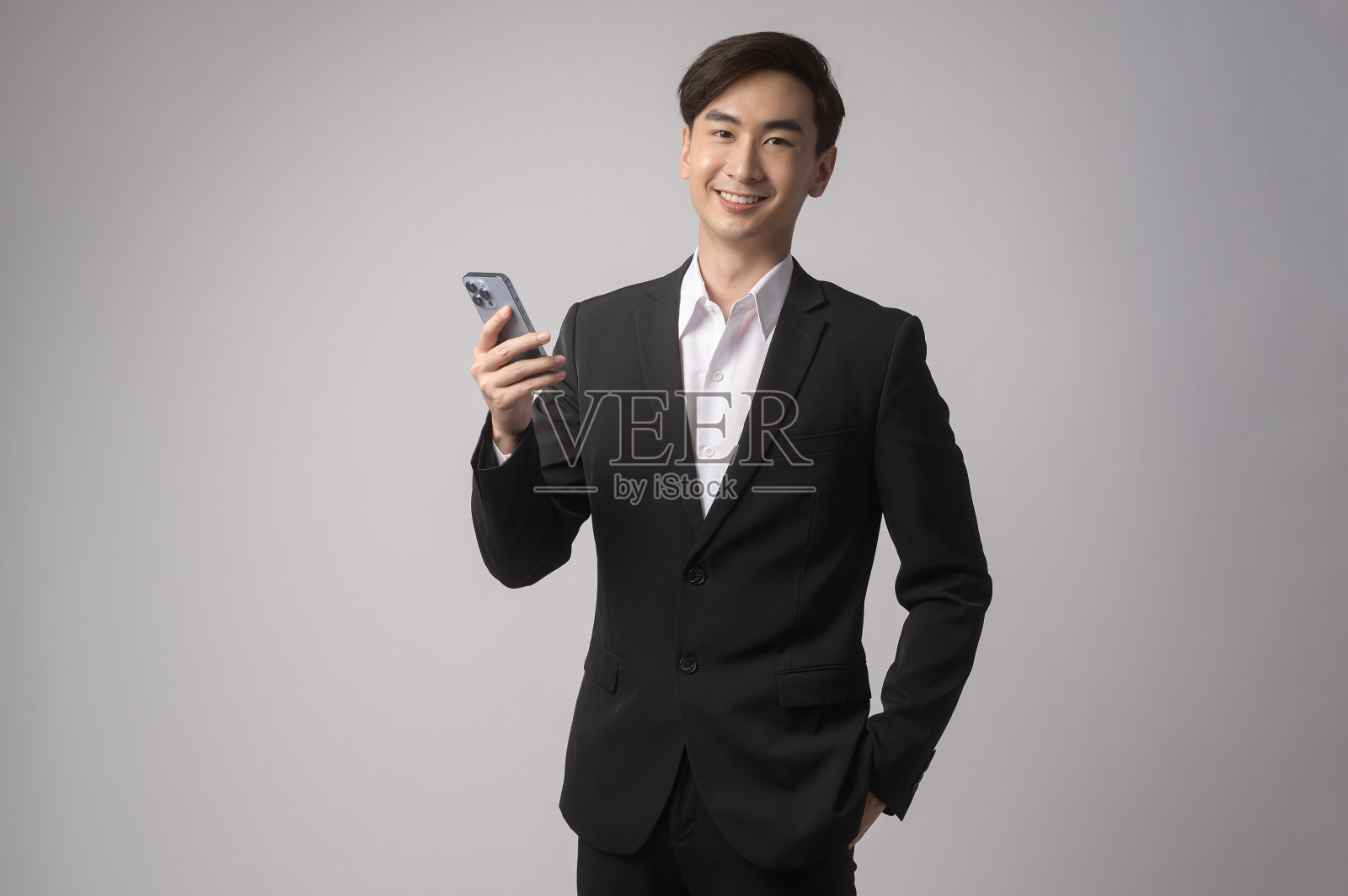 年轻的商人穿着西装在白色背景的工作室照片摄影图片