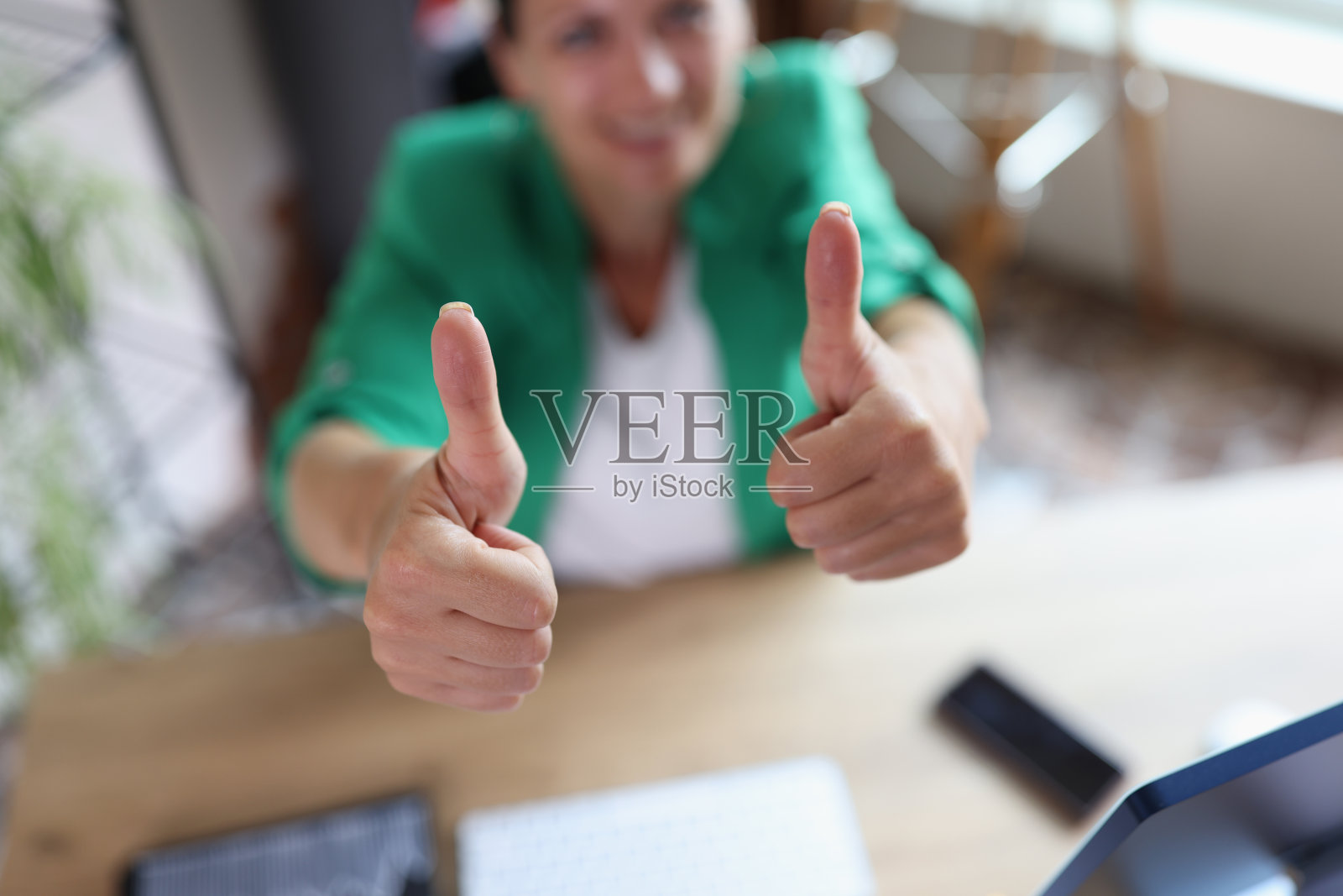 成功的商业女性在办公室的工作场所竖起大拇指照片摄影图片
