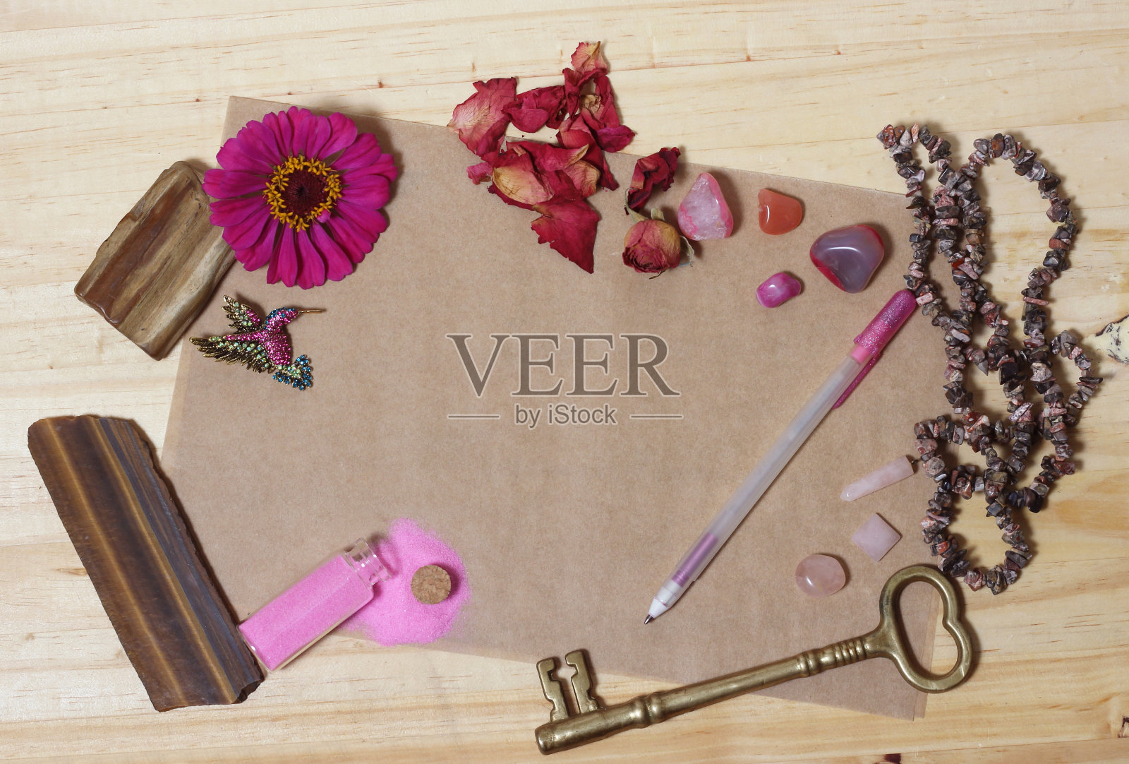 旧纸上的粉色花朵，粉色石头和黄铜钥匙照片摄影图片