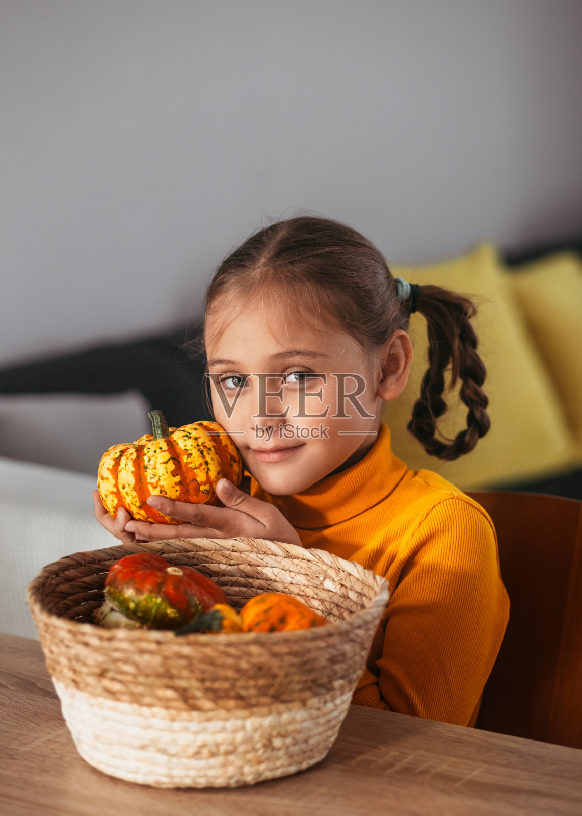 小女孩玩南瓜。家里的情感画像。万圣节派对的概念。垂直照片摄影图片