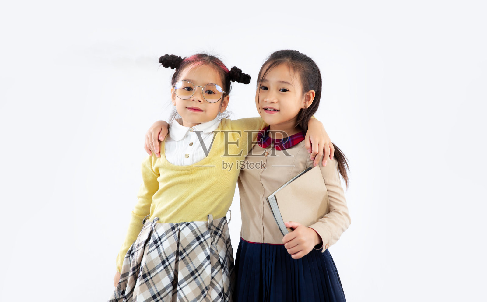 回到学校。亚裔小女生在白色背景下摆姿势。照片摄影图片