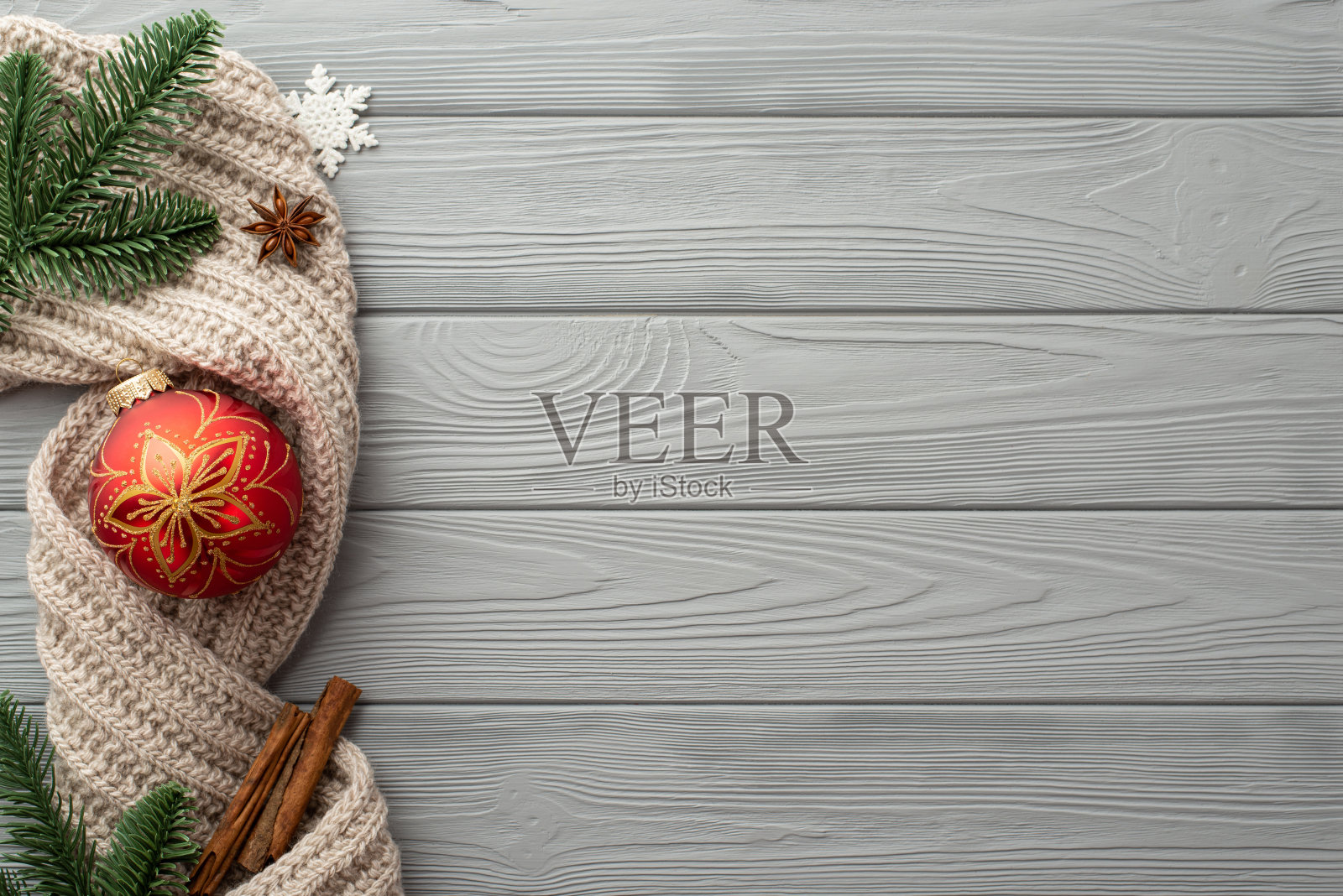 圣诞装饰品的概念。顶视图照片红色小花絮雪花松枝针织围巾八角和肉桂棒在灰色木桌背景与copyspace照片摄影图片