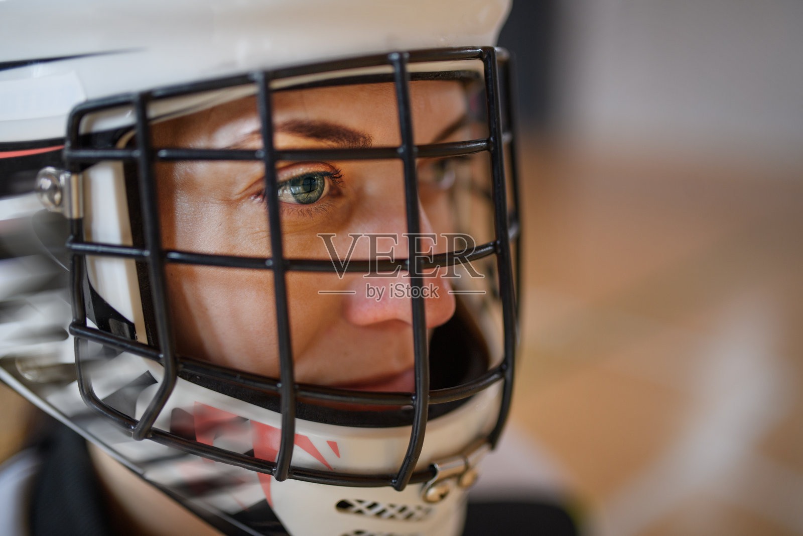 戴着头盔的女子地板守门员在体育馆专注于比赛的特写。照片摄影图片
