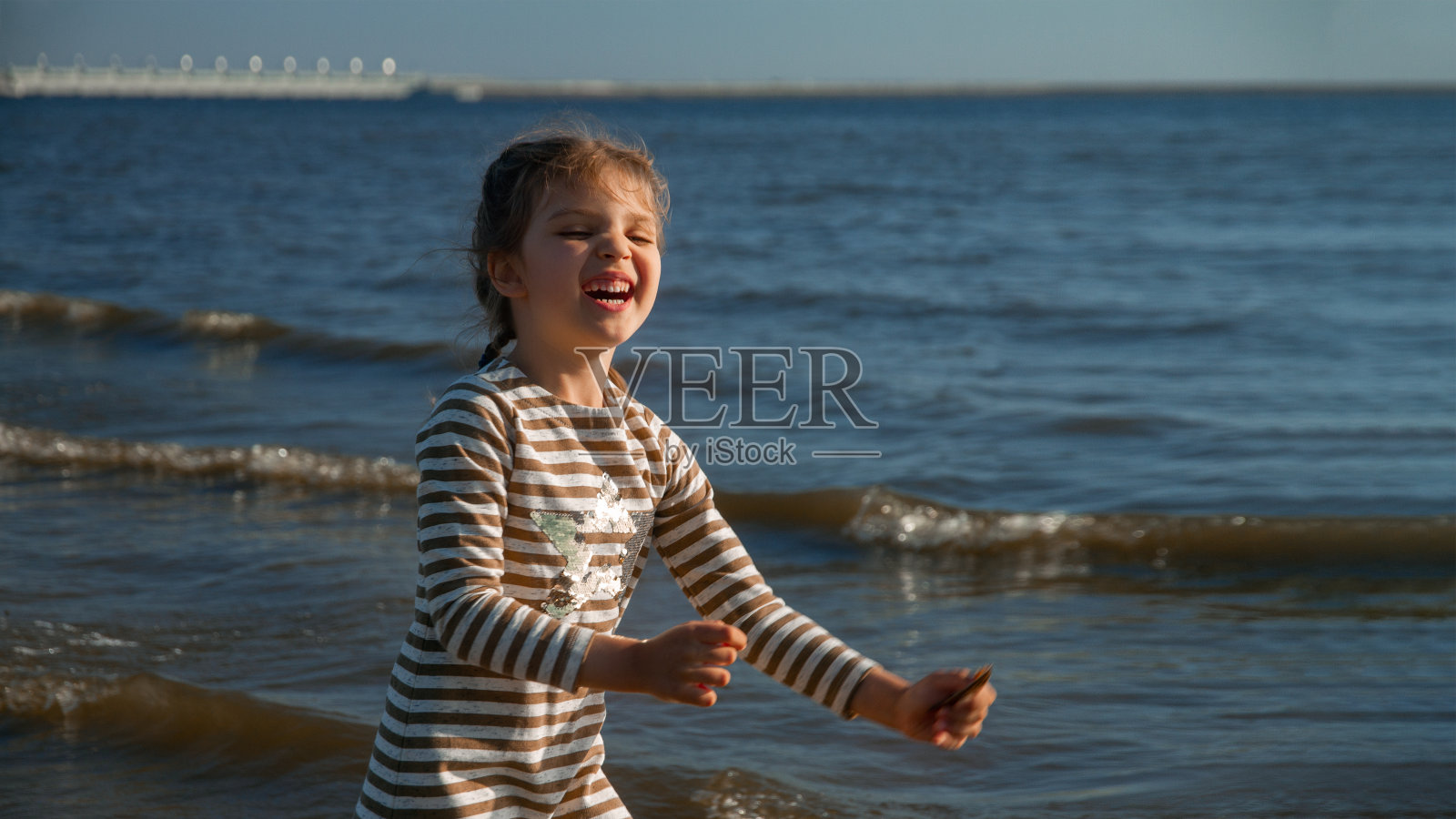 笑了4年的女孩穿着在沙滩上快乐的夏天，选择性的关注照片摄影图片