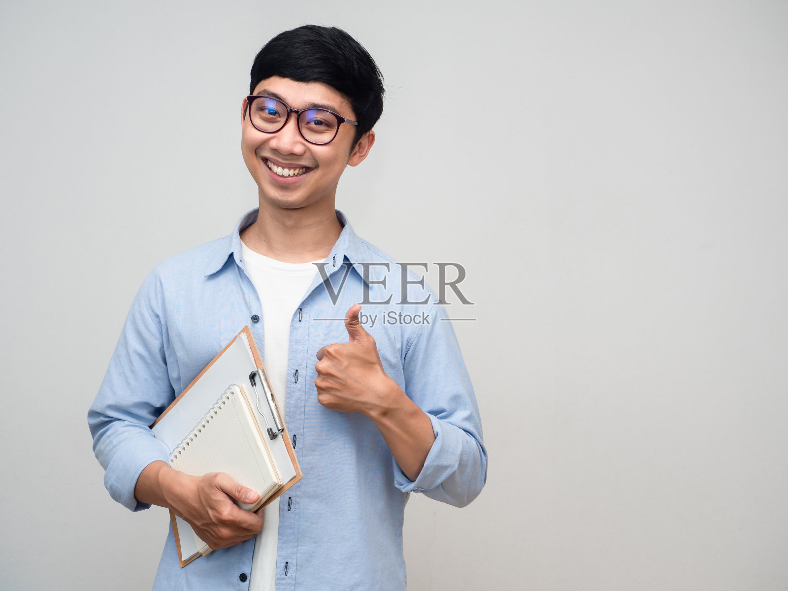 开朗的商人拿着文件和日记，竖着大拇指孤立地看照片摄影图片