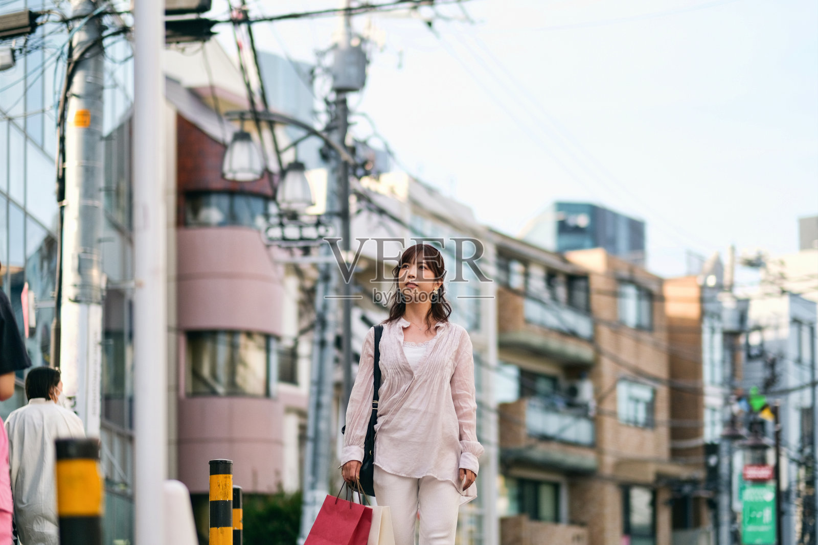 妇女手里拿着购物袋走在街上照片摄影图片