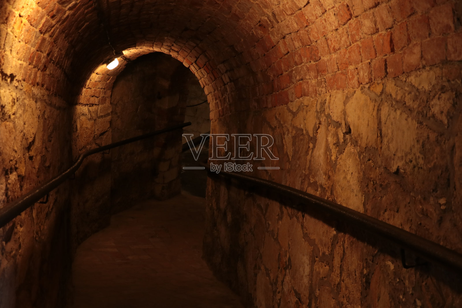 进入一个黑暗的长地下室，石头结构，避难所。照片摄影图片