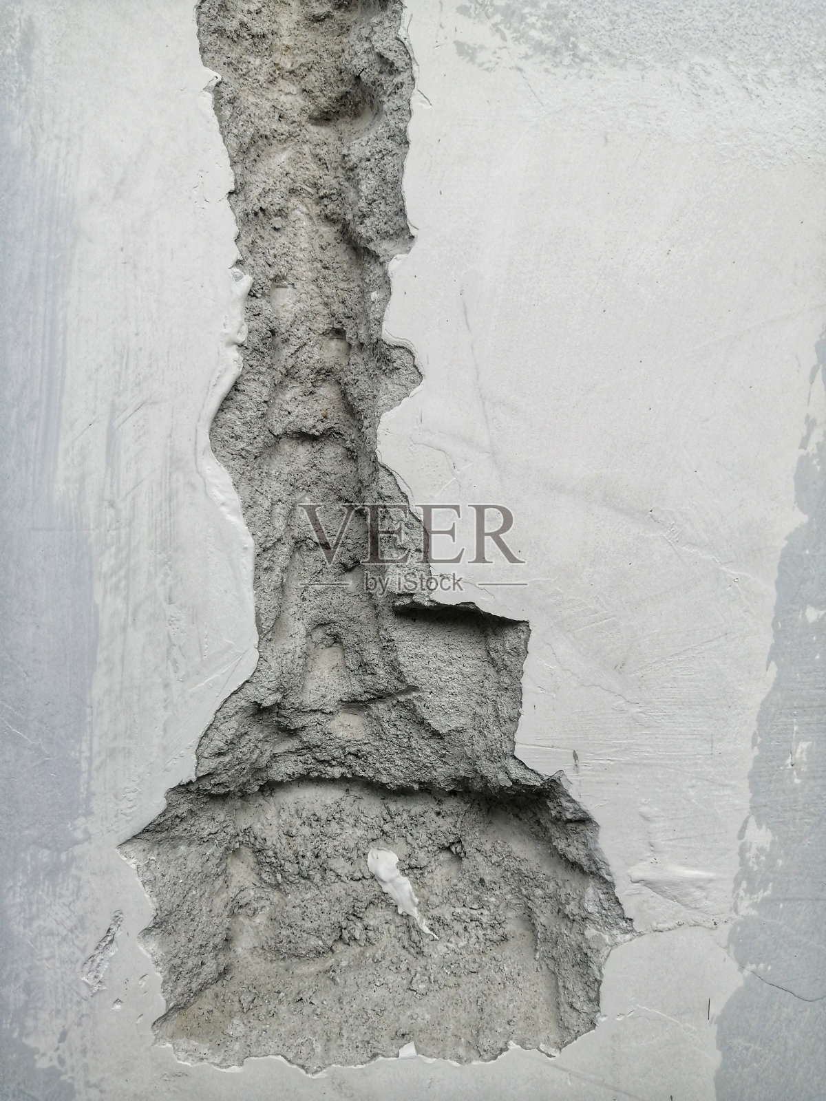 工人在白砖墙上为安装电线而做的深深的沟槽和孔洞。为了安装电缆，墙被打破了。照片摄影图片