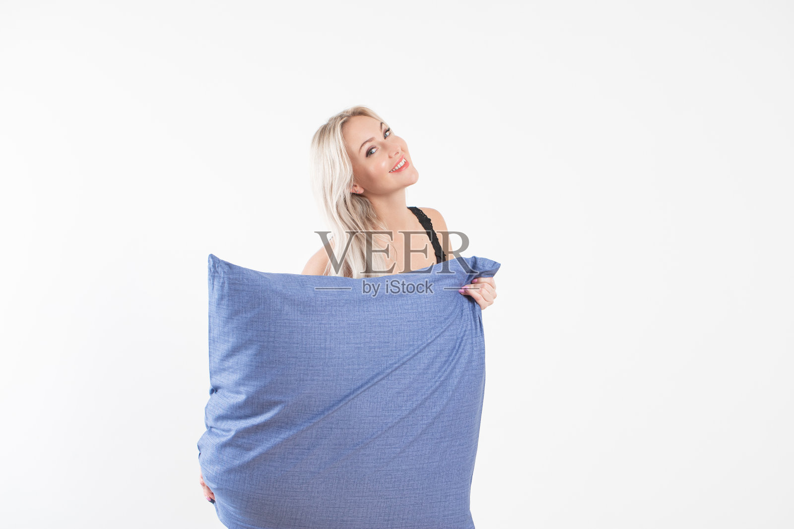 金发女孩在床上白色枕头和毯子在明亮的卧室，家用纺织品照片摄影图片