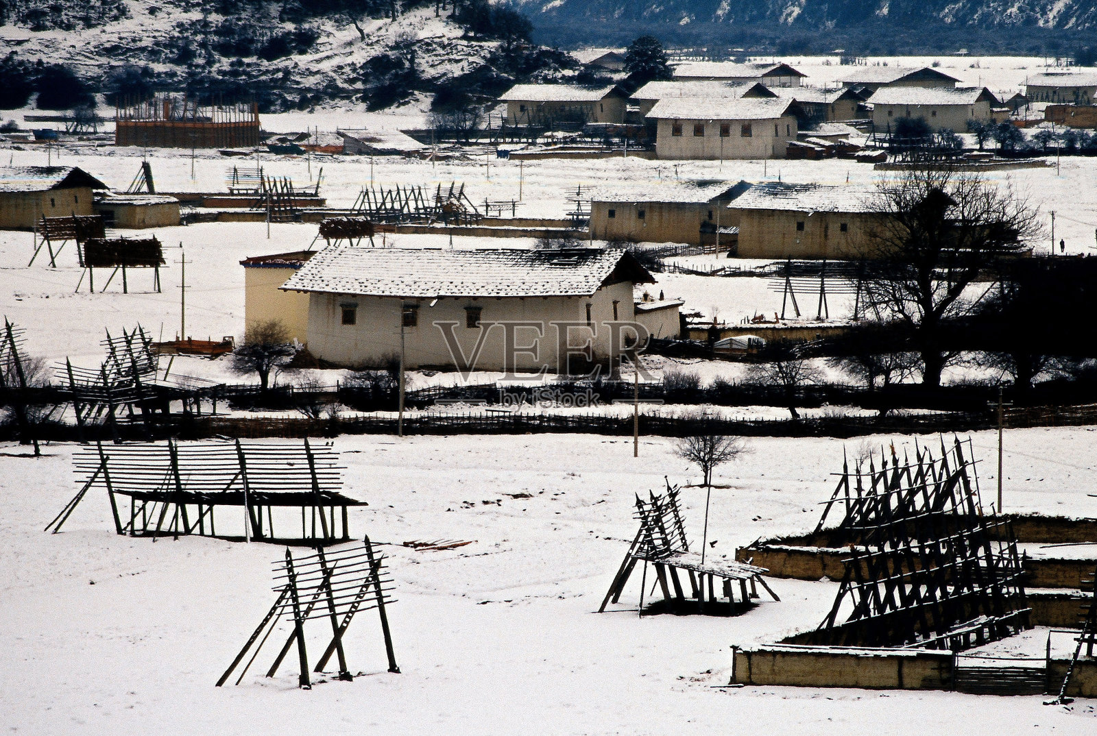 藏族村庄和雪后的草堆框架照片摄影图片