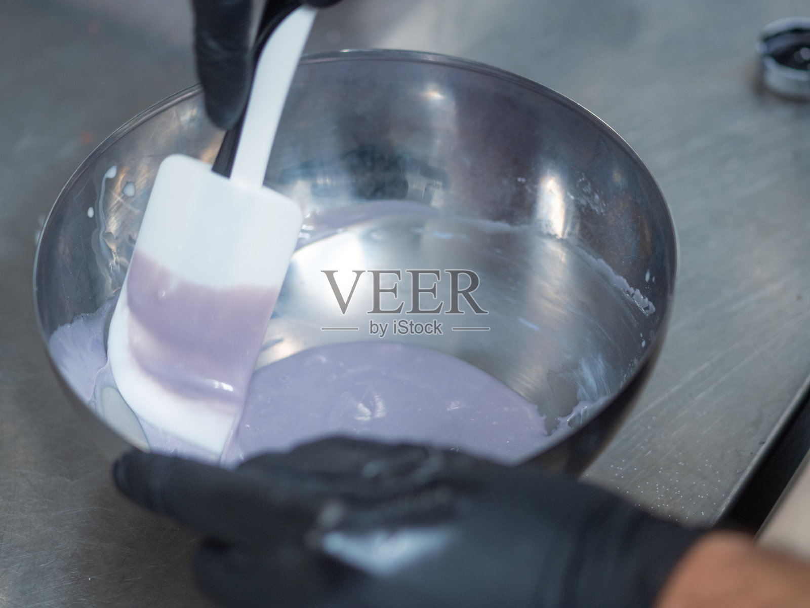 厨师准备糖衣袋填充白巧克力滴和丁香色素照片摄影图片