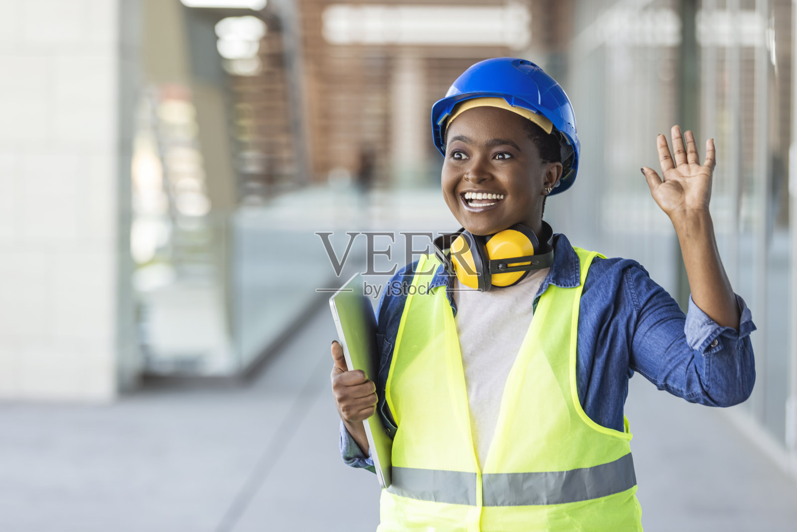 女建筑师带着露齿的微笑，戴着头盔，穿着时髦的休闲装照片摄影图片