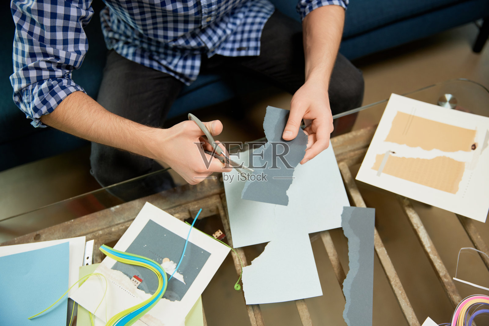 手工艺成为一种成熟的爱好。裁剪的形象男子举行了贴花，quilling和录音vlog在家庭工作室的大师班。爱好和休闲活动。照片摄影图片