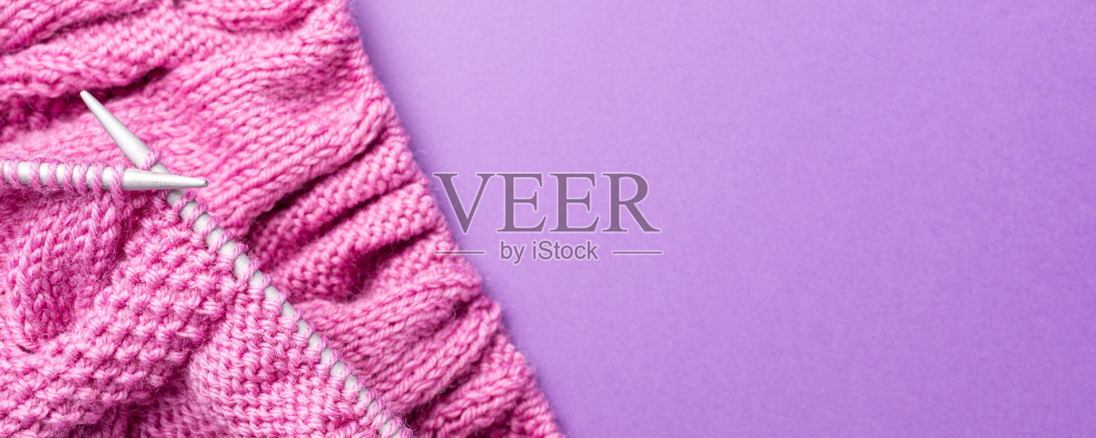 横幅与针织平铺与粉色羊毛纱和针织配件在紫丁香，顶视图，头顶拍摄与复制空间照片摄影图片