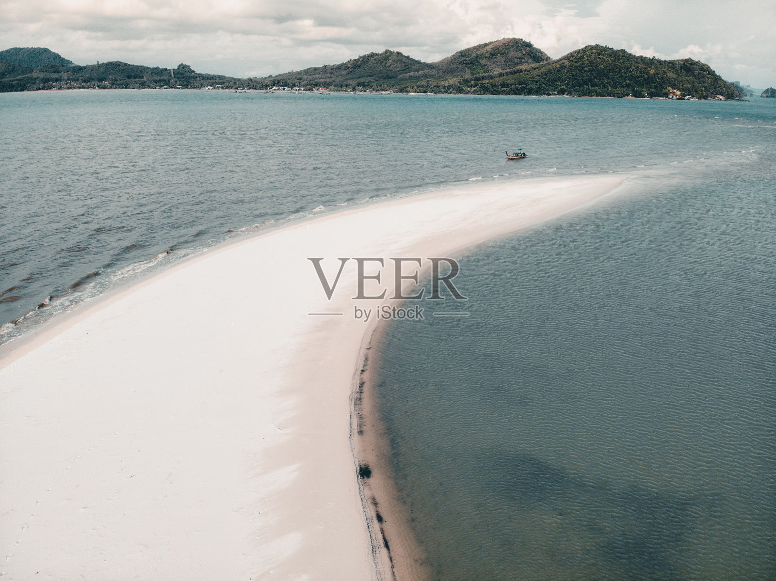 鸟瞰白色的沙滩上绿松石的水与绿色的树木和悬崖照片摄影图片