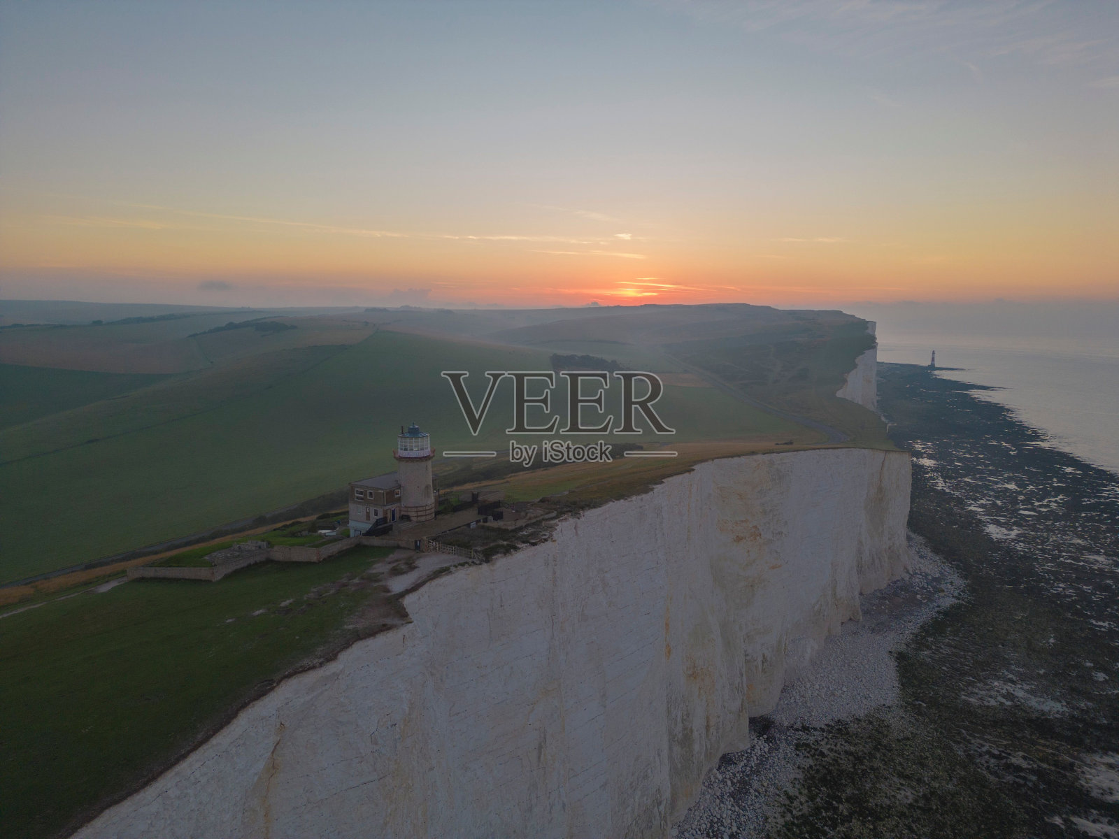 日出时分，英国东苏塞克斯比奇黑德的贝尔图特灯塔的航拍照片照片摄影图片