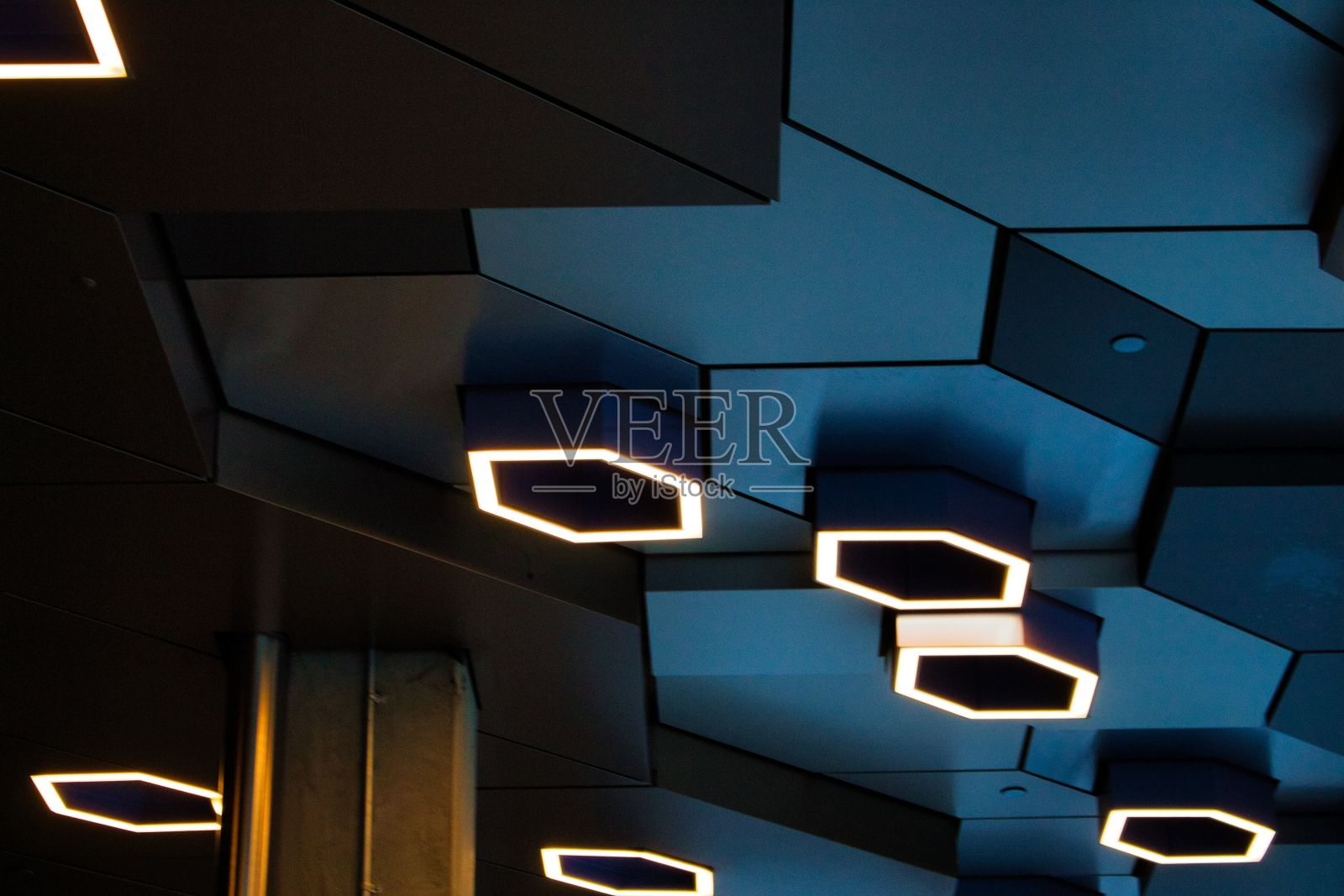 蓝色天花板和抽象六角形灯的建筑内部视图照片摄影图片