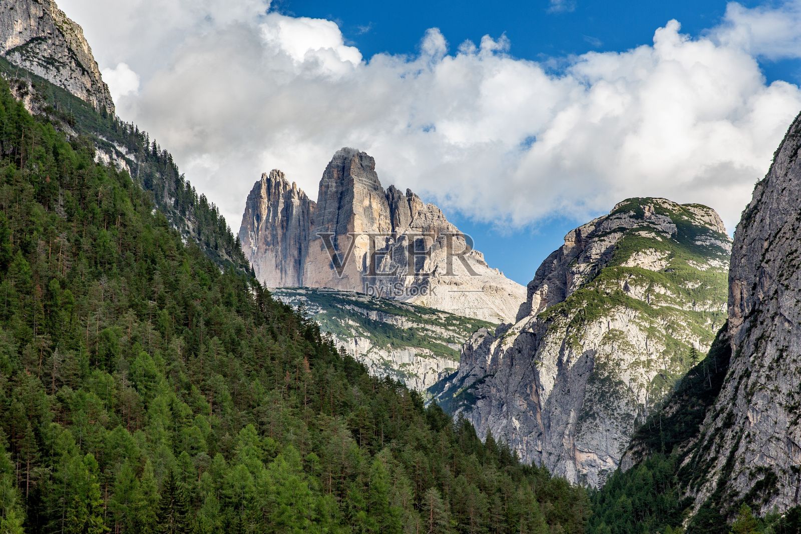 多岩石的山峰衬着蓝色多云的天空的美丽景色照片摄影图片