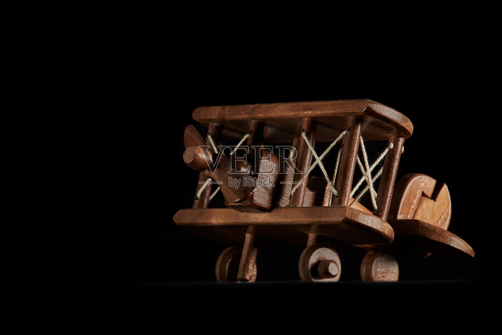 黑色背景上的经典木制飞机玩具特写镜头照片摄影图片