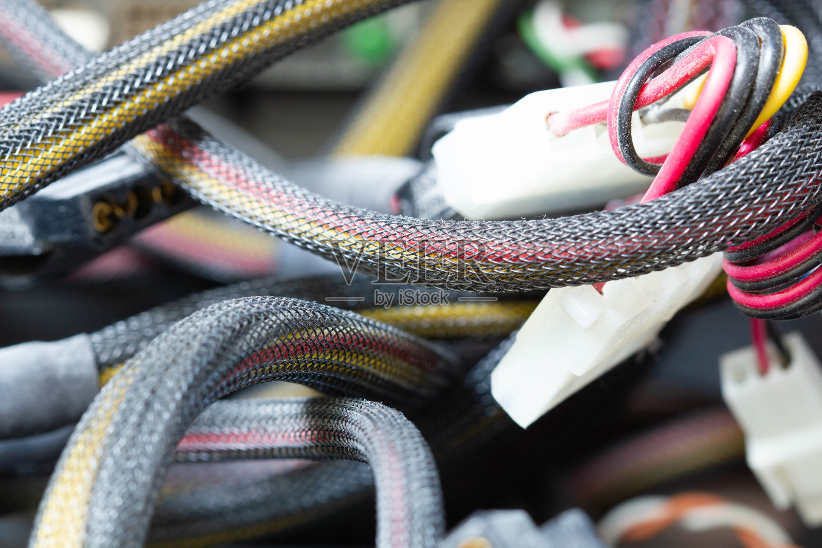 电脑里的电线、连接器和插头都很脏。旧的多色电线在编织的包装。电子设备中的绞线。电子维修服务车间。照片摄影图片