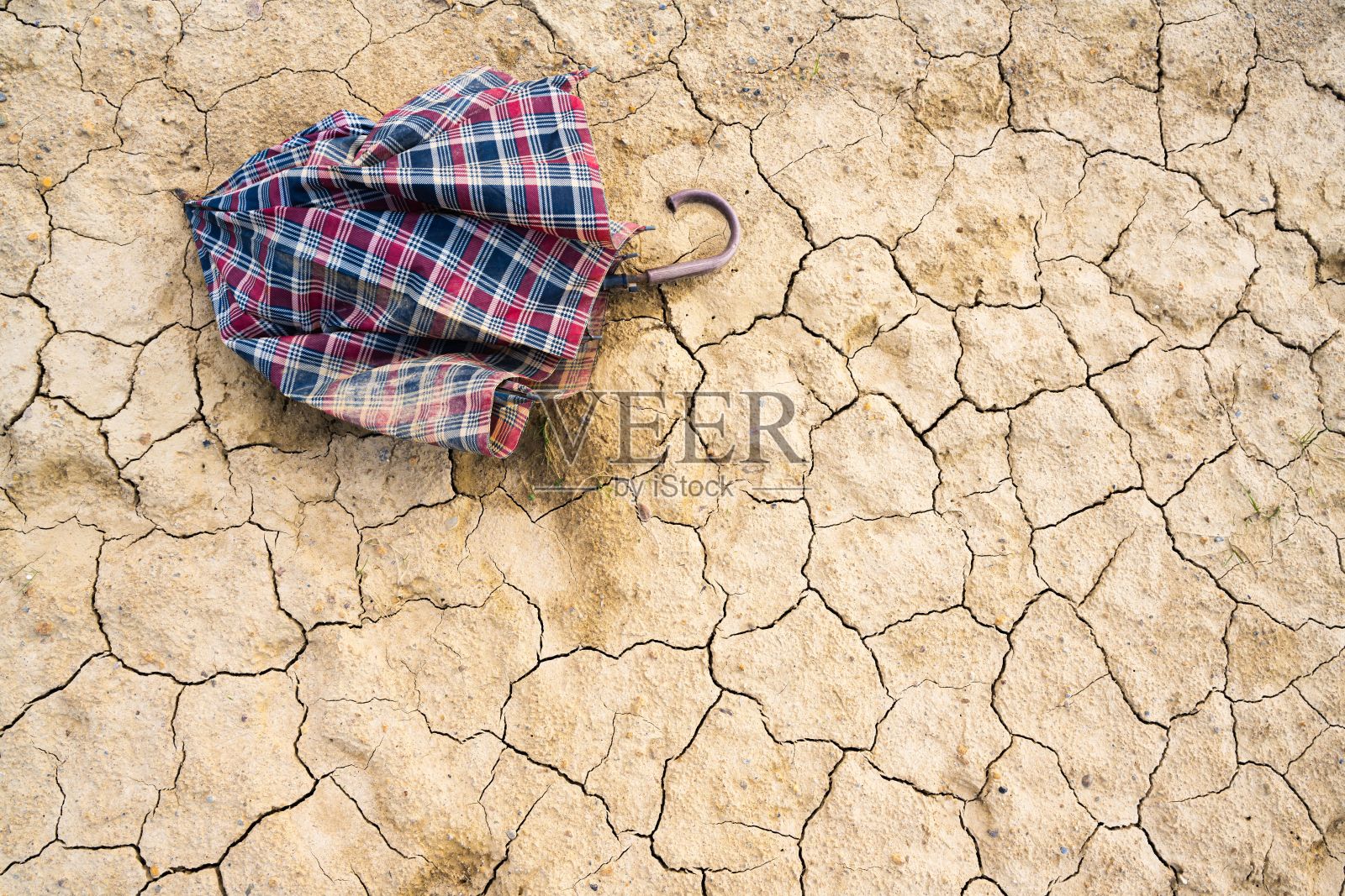 在干裂的土地上用伞拍摄细节特写照片摄影图片