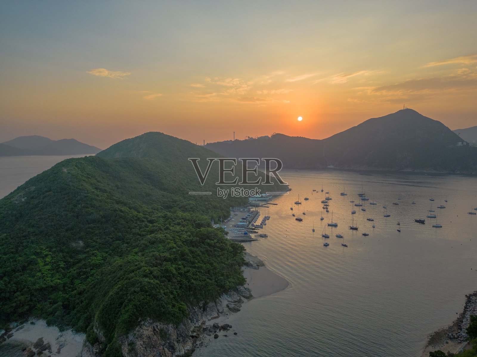 海上航拍，船在日落时被青山环绕照片摄影图片