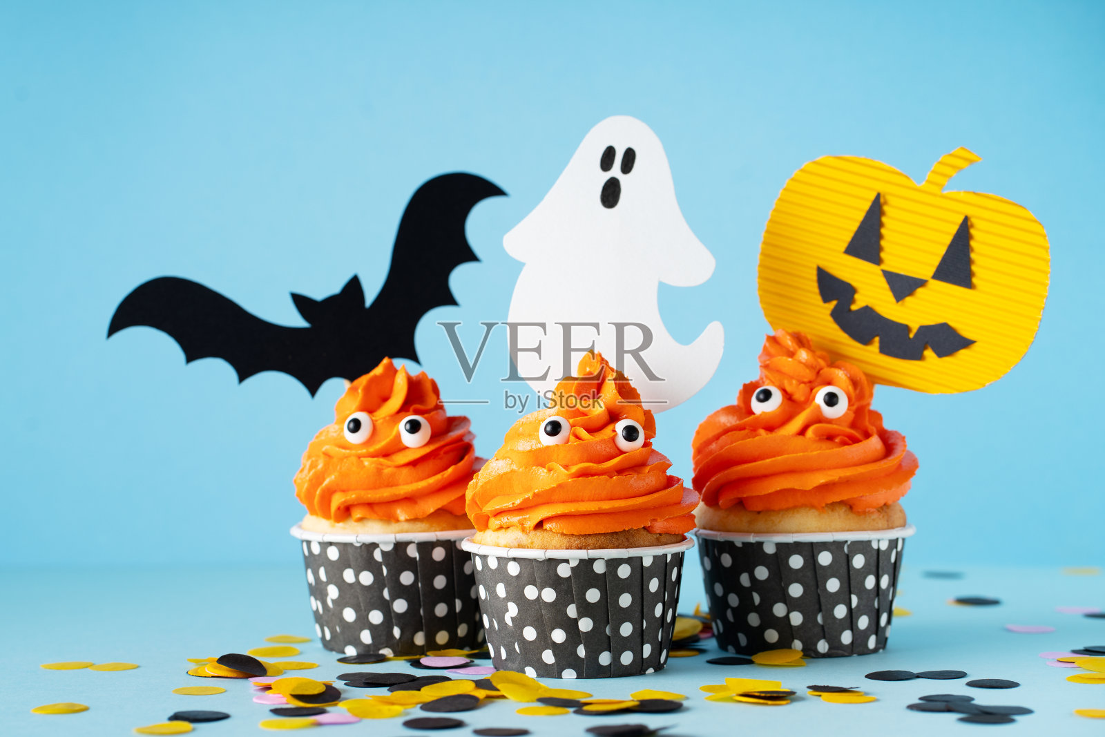 怪物橙色带眼睛的有趣纸杯蛋糕，万圣节照片摄影图片