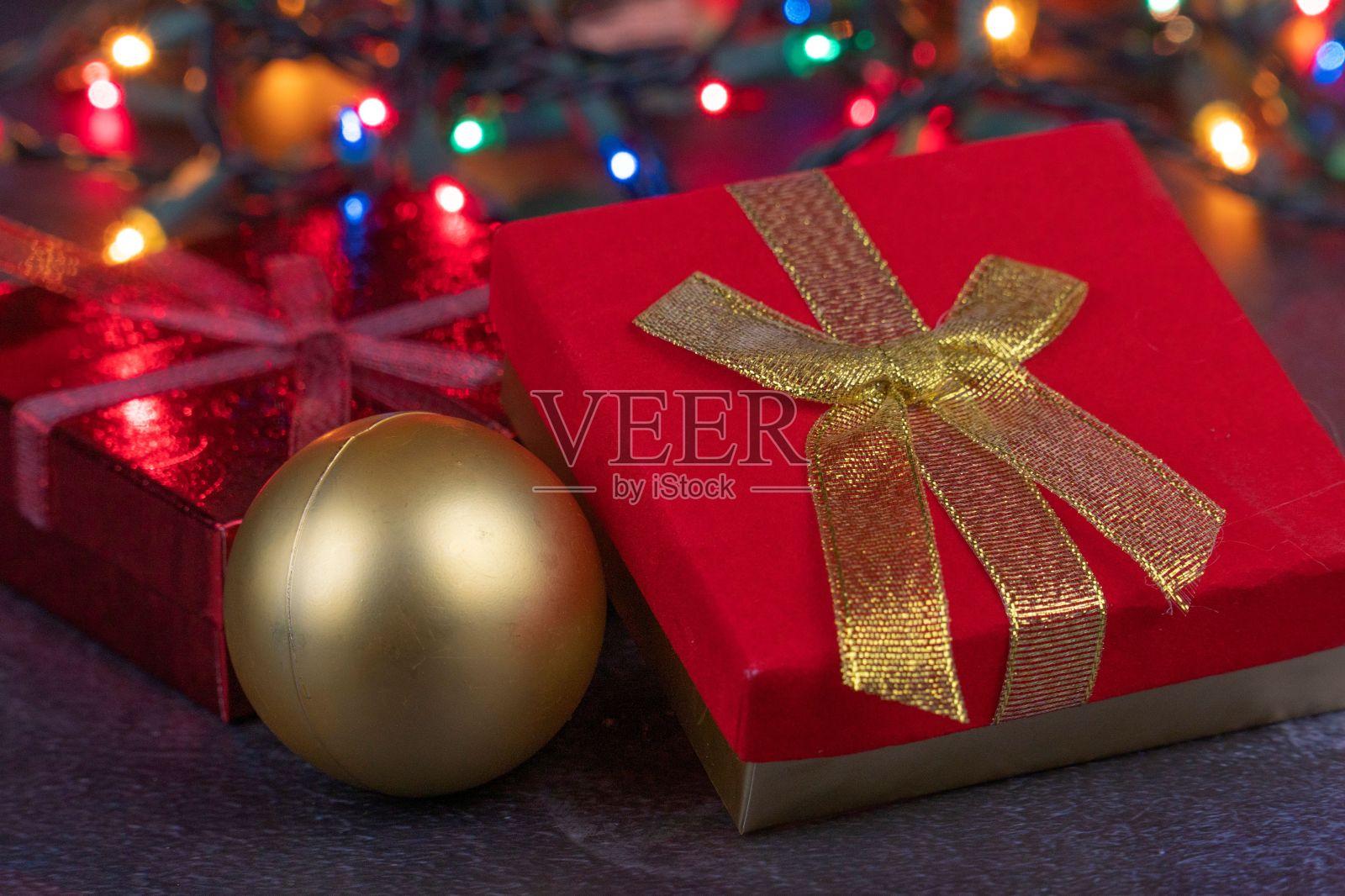 特写的圣诞球，礼盒，和发光的灯光在背景照片摄影图片