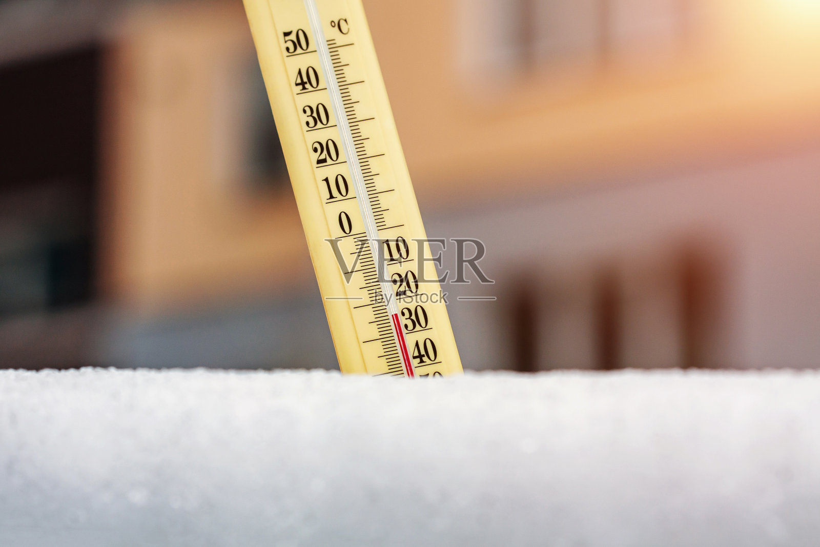 冬季。雪地里的温度计显示，在多层建筑的背景下，温度非常低。零下24度。天气预报的概念。照片摄影图片