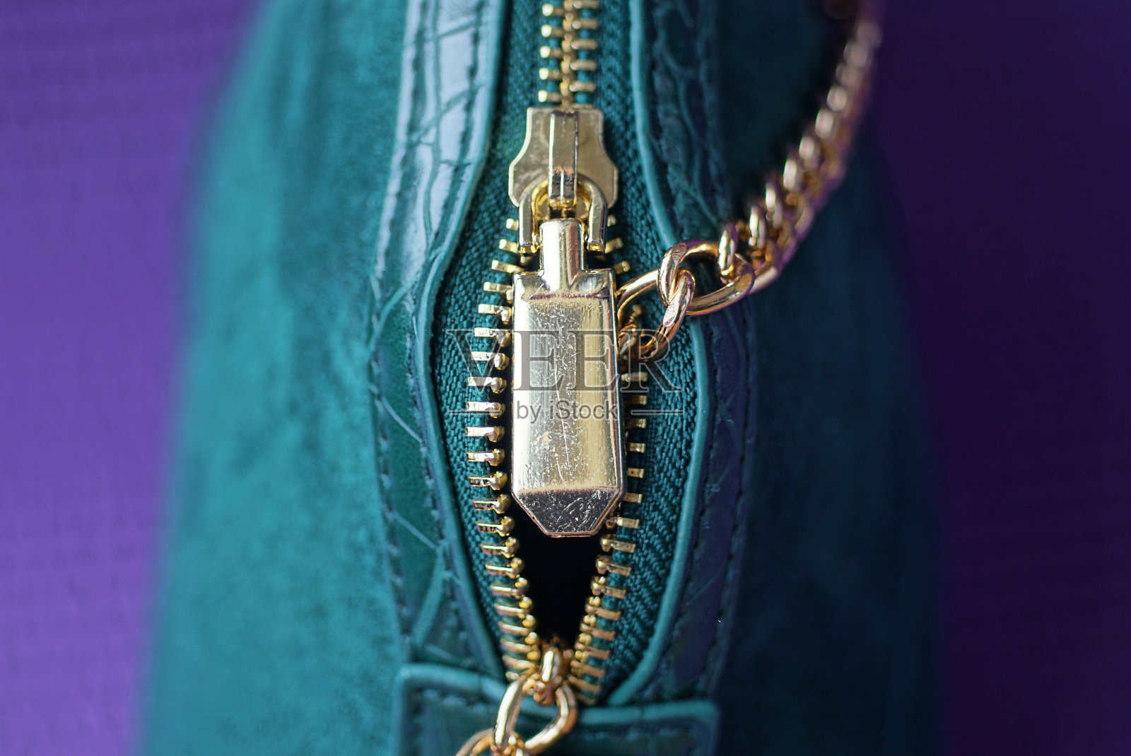 一个绿色皮包上的黄色金属拉链照片摄影图片