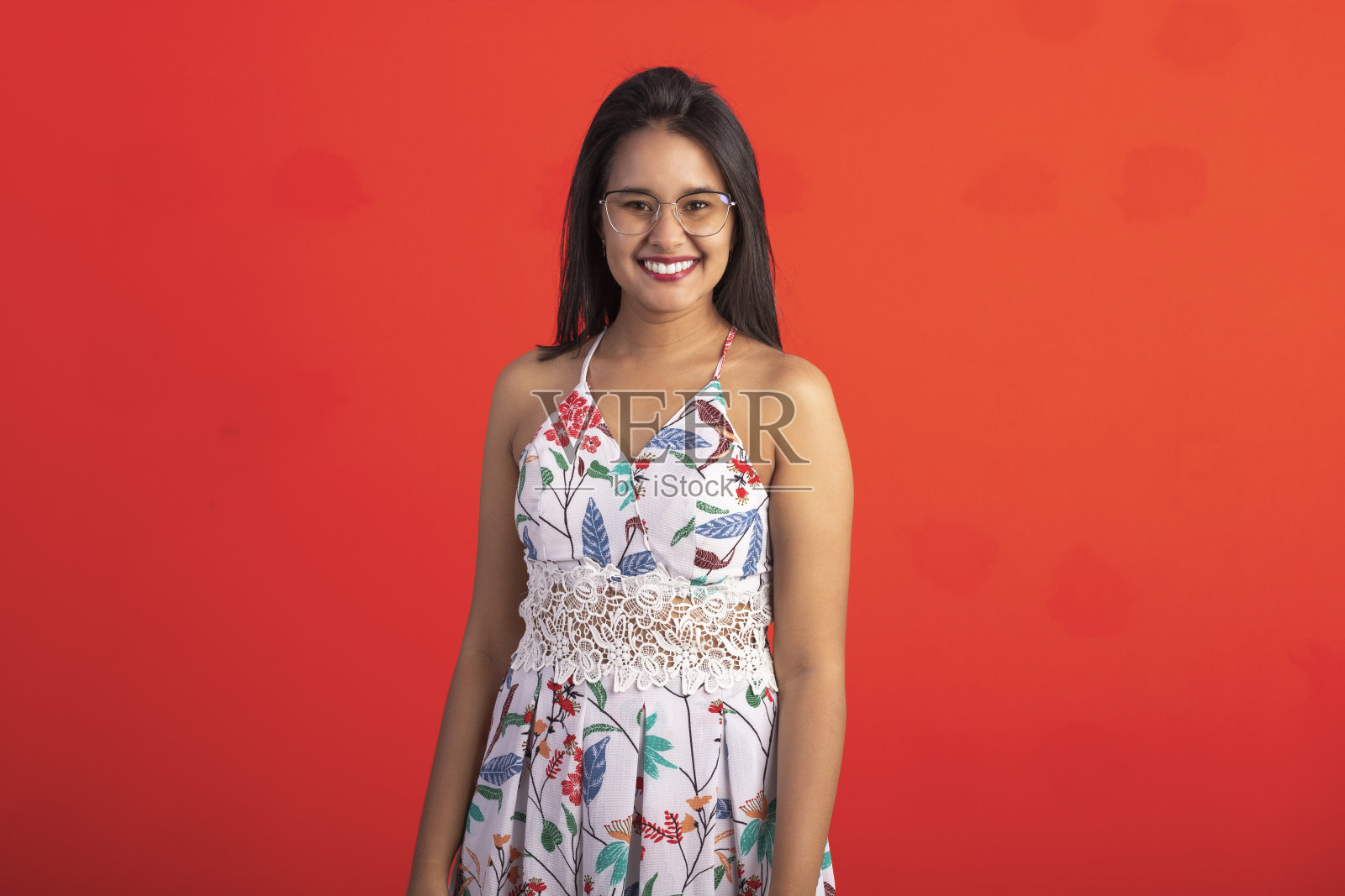 巴西褐发女子在花卉印花连衣裙在工作室戴眼镜和太阳镜照片摄影图片