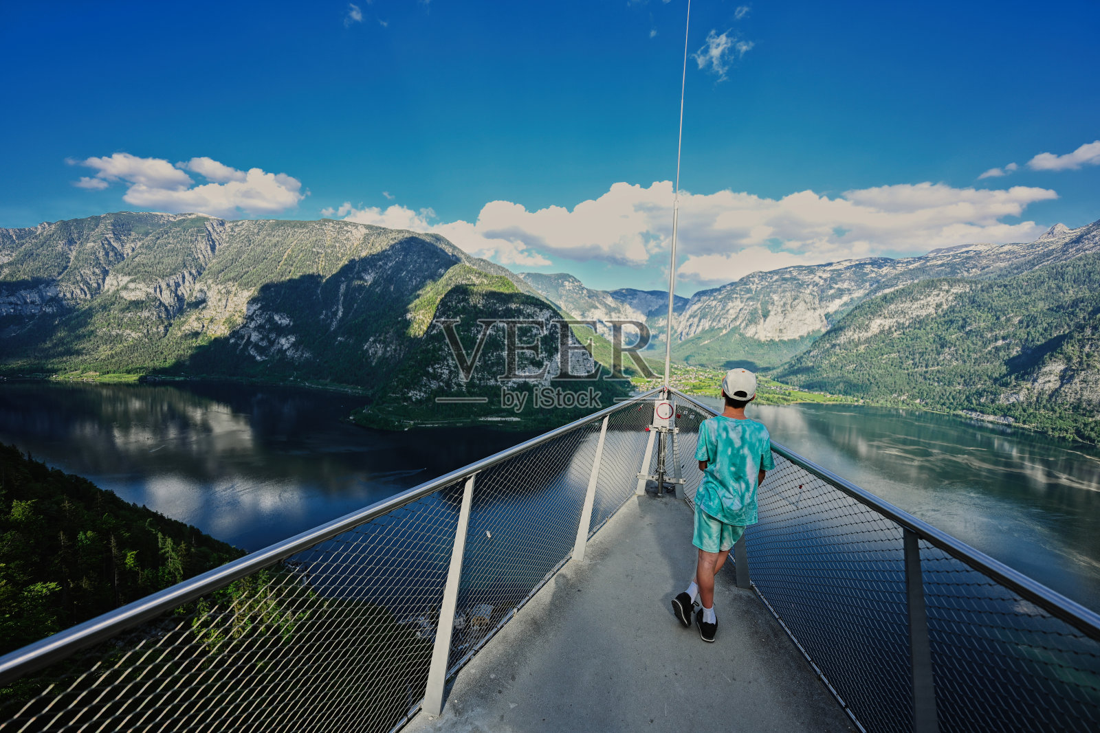 在奥地利哈尔斯塔特的观景桥上，男孩的背影。照片摄影图片