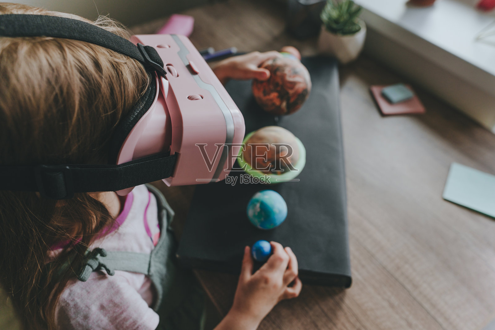 小女孩在家里使用VR眼镜学习太阳系的行星照片摄影图片