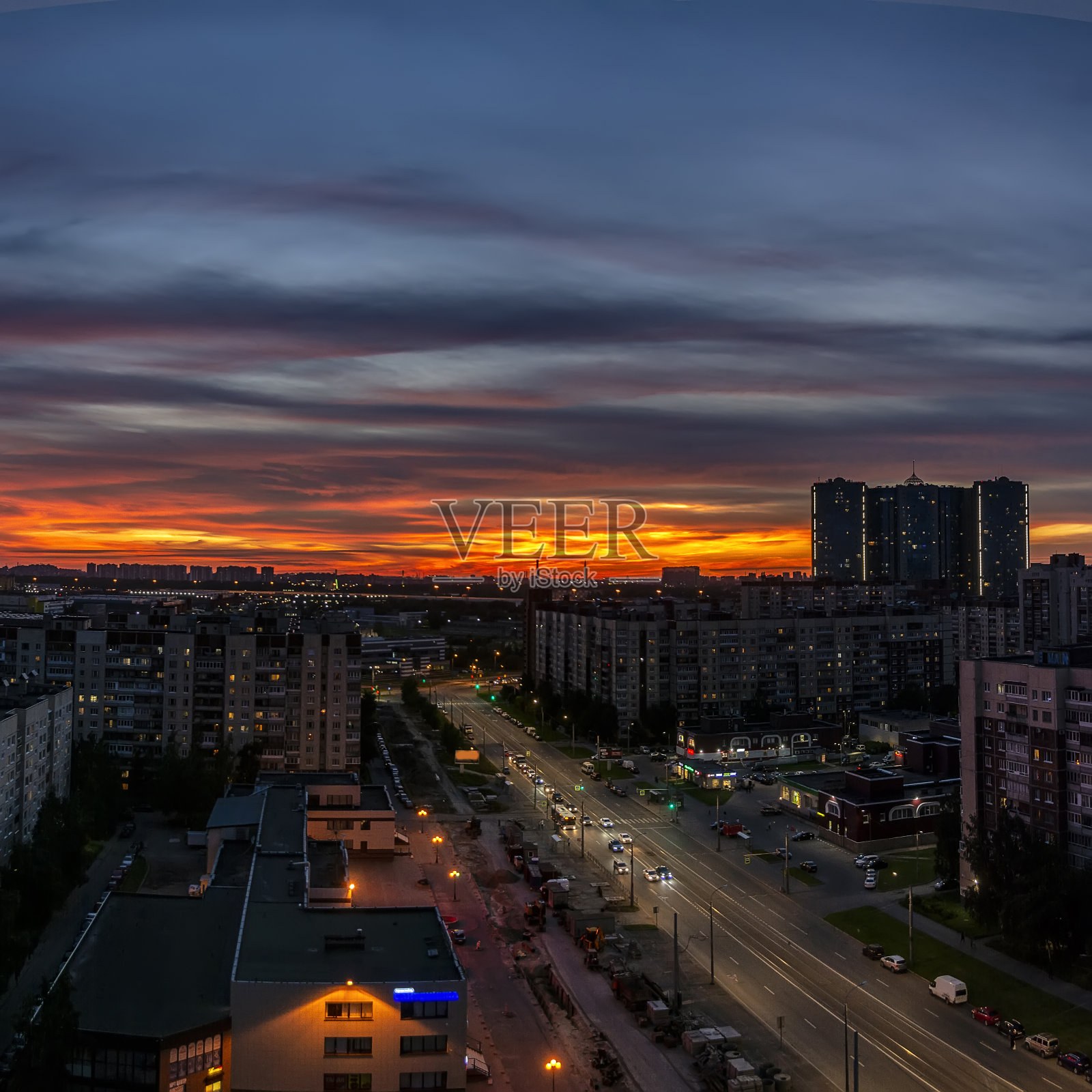 从高楼上拍摄的城市明亮的夏日日落。照片摄影图片