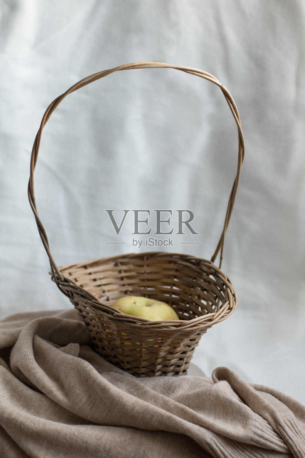 一个苹果放在一个舒适的空间里的柳条篮子里照片摄影图片