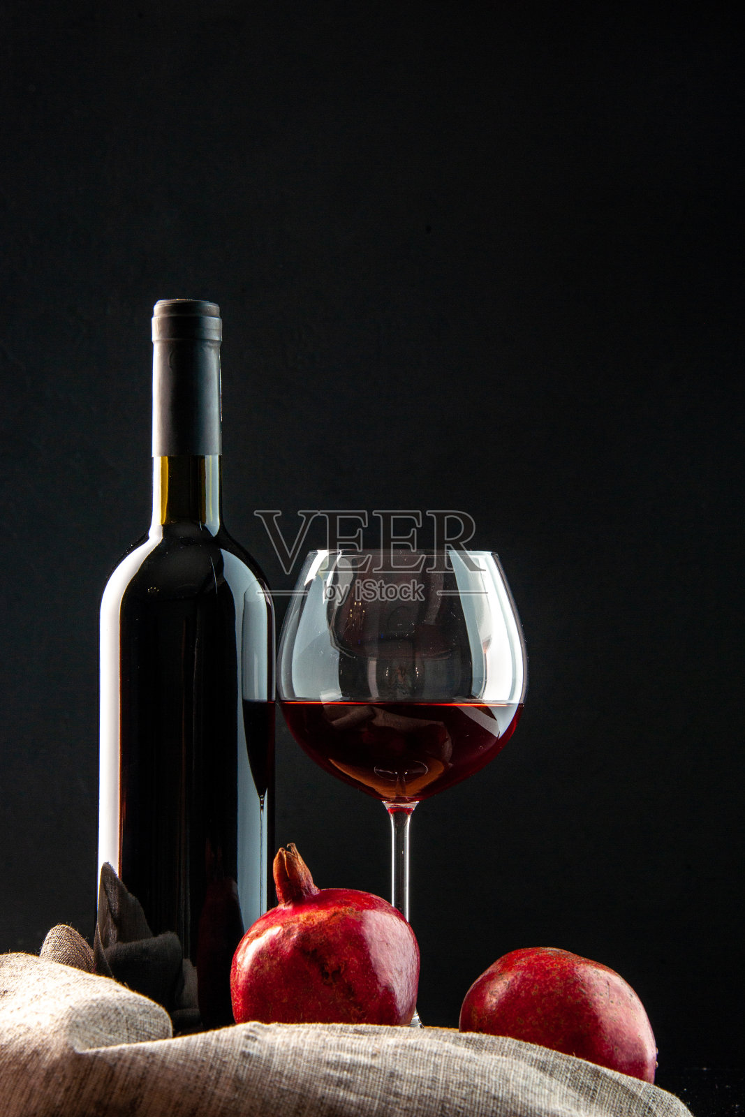 特写的一杯红酒与一瓶葡萄酒放在一个木板背景照片摄影图片