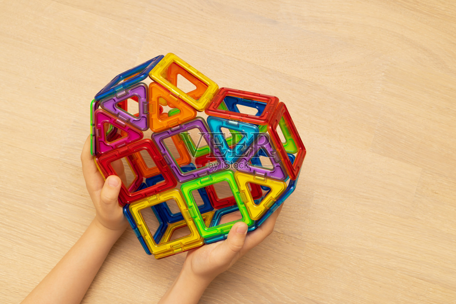 孩子们玩着五颜六色的磁性积木。照片摄影图片