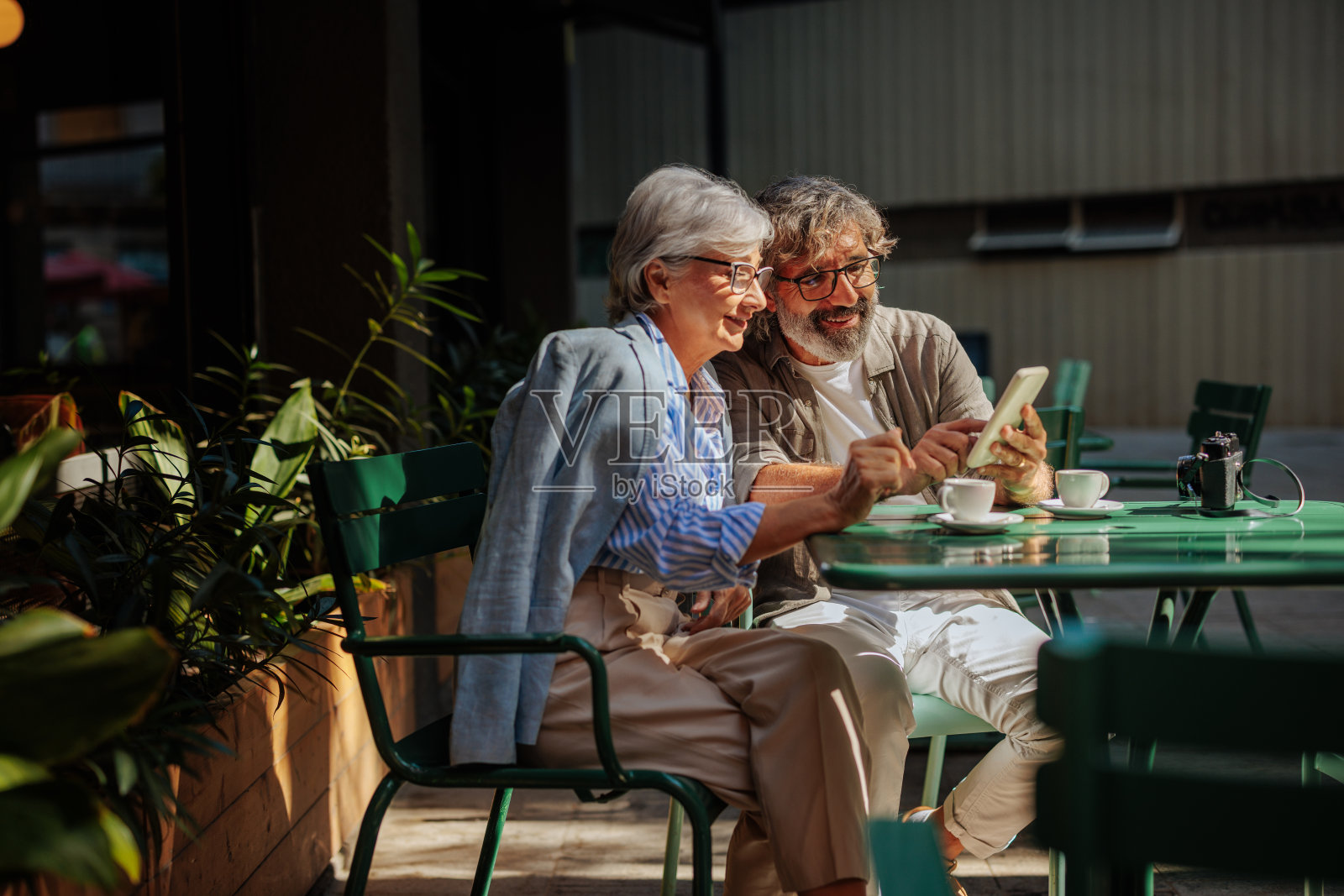 老夫妇在咖啡馆使用智能手机。照片摄影图片