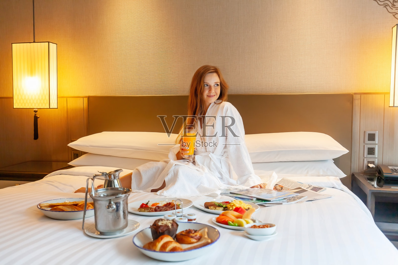 床上的食物供应在豪华酒店，度假的女人享受早餐照片摄影图片