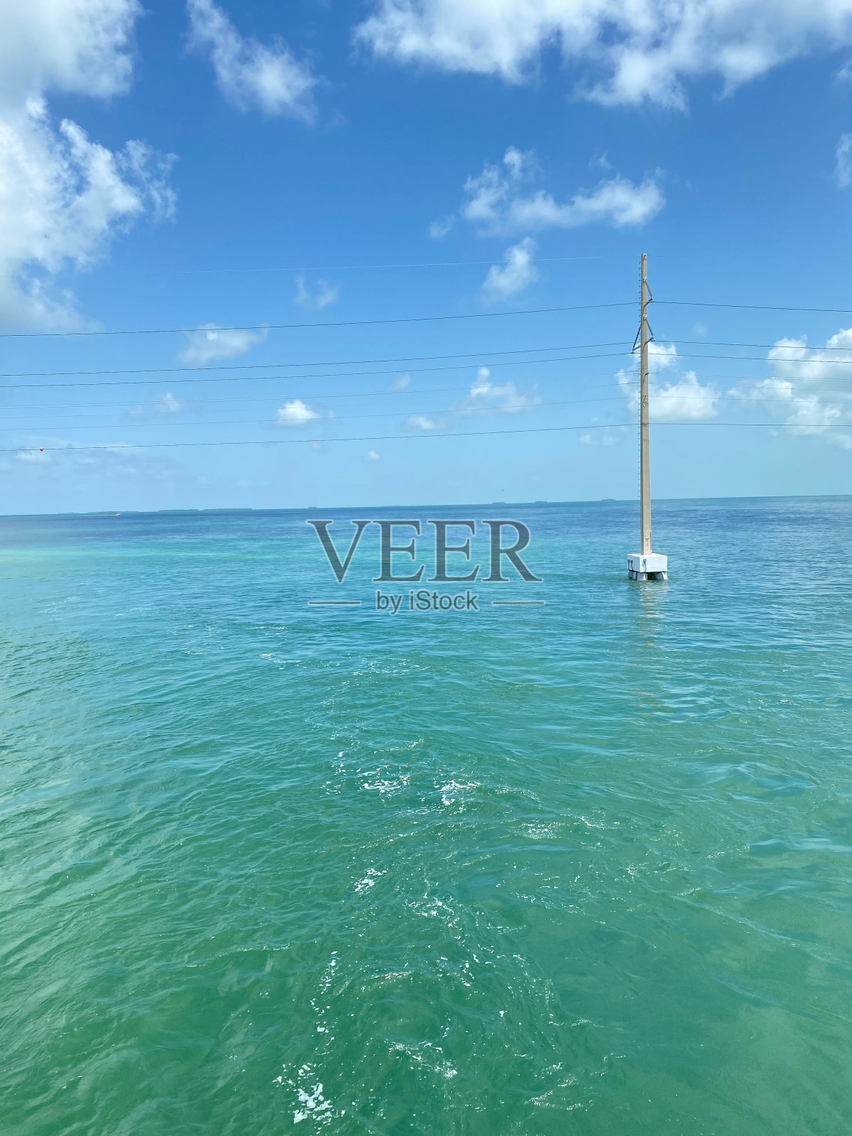 海洋中电力塔的垂直镜头。照片摄影图片