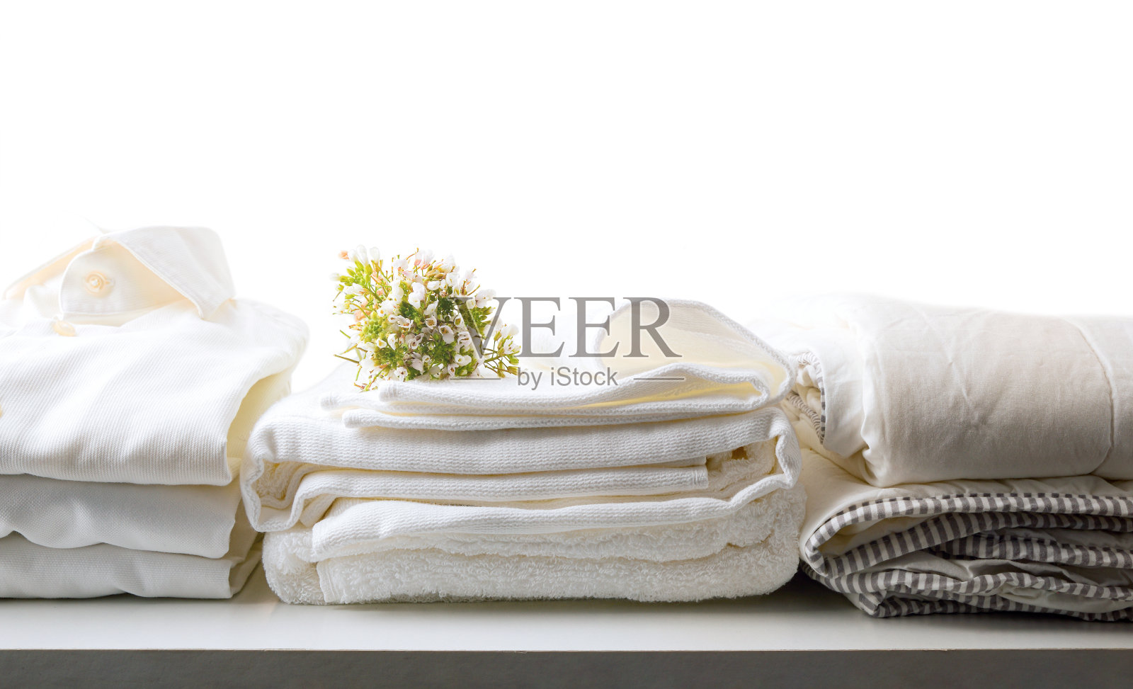 白色干净的床和衣服放在桌子上孤立的背景照片摄影图片