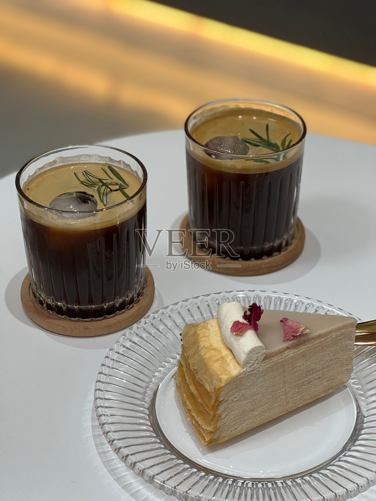 一块蛋糕和两杯鸡尾酒，放在白色的桌子上照片摄影图片